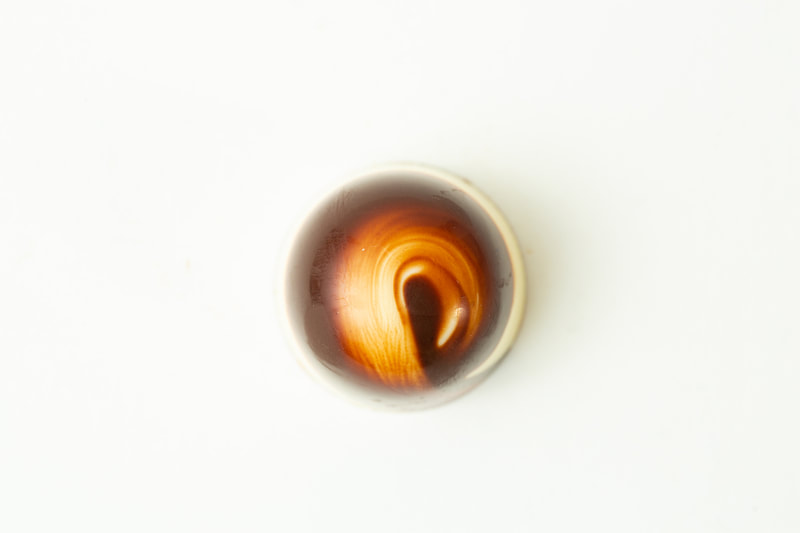White and dark marbled shell filled with a creamy milk and hazelnut ganache.