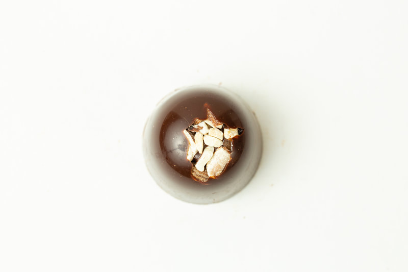 Dark chocolate filled with creamy dark ganache and topped with dry roasted almonds.